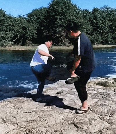 两小伙玩斗鸡游戏，一不小心跌到了水里