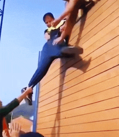 一群人助力翻墙，没想到裤子被扯烂了