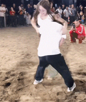 沙地里的男女摔跤比赛，看得出双方都很卖力